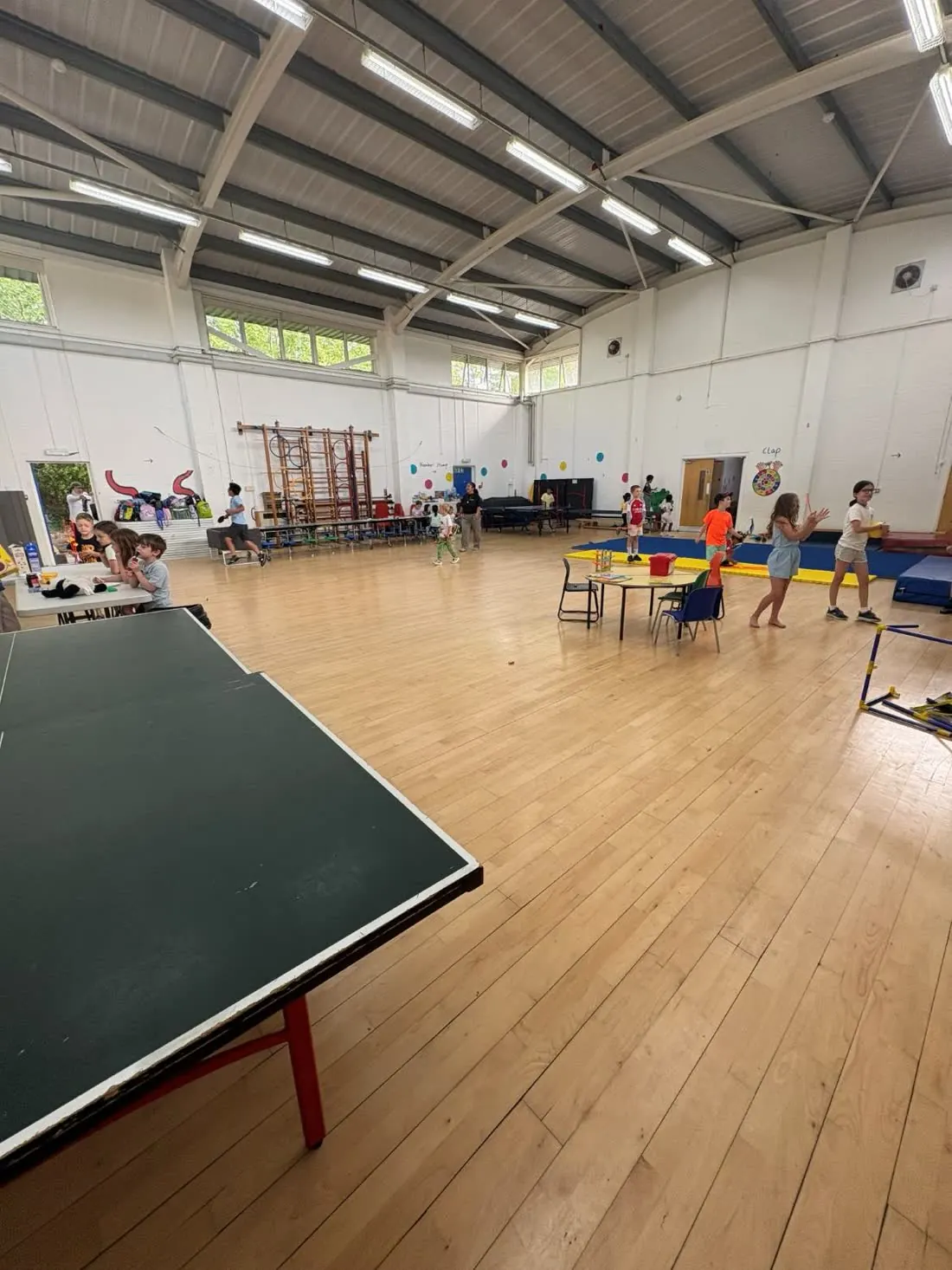 The school hall at camp with children playing table tennis, crafts and gymnastics