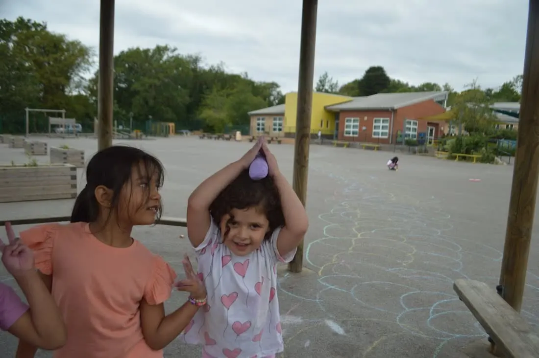Children drawing with chalk in the school playground at camp
